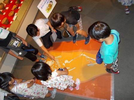 写真：神明貝塚で発見された人骨の解説を聞く子どもたち