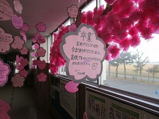 昇降口に飾られた桜の木と花びらにメッセージが書かれた装飾